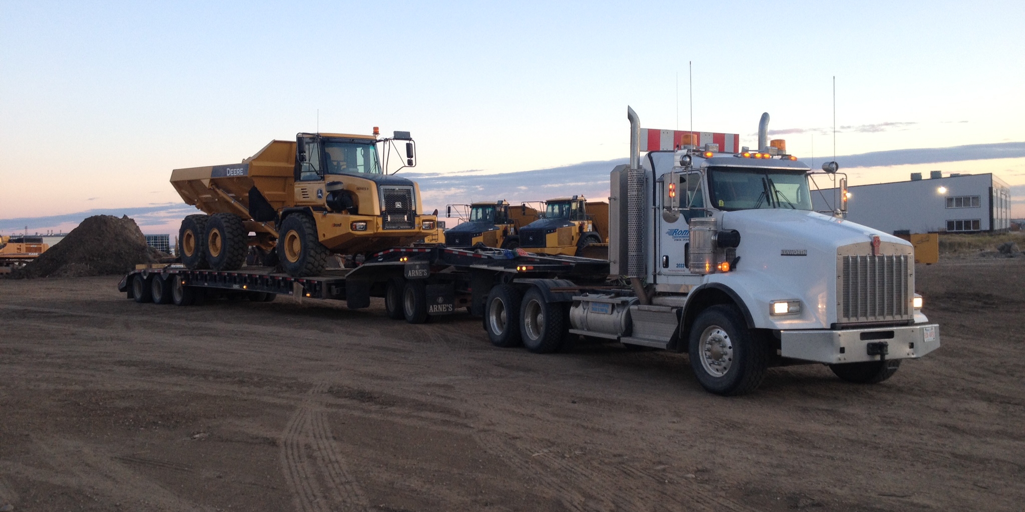 Romers tandem truck hauling rock truck to job site