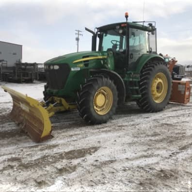 Tractor with shovel on front to push snow.